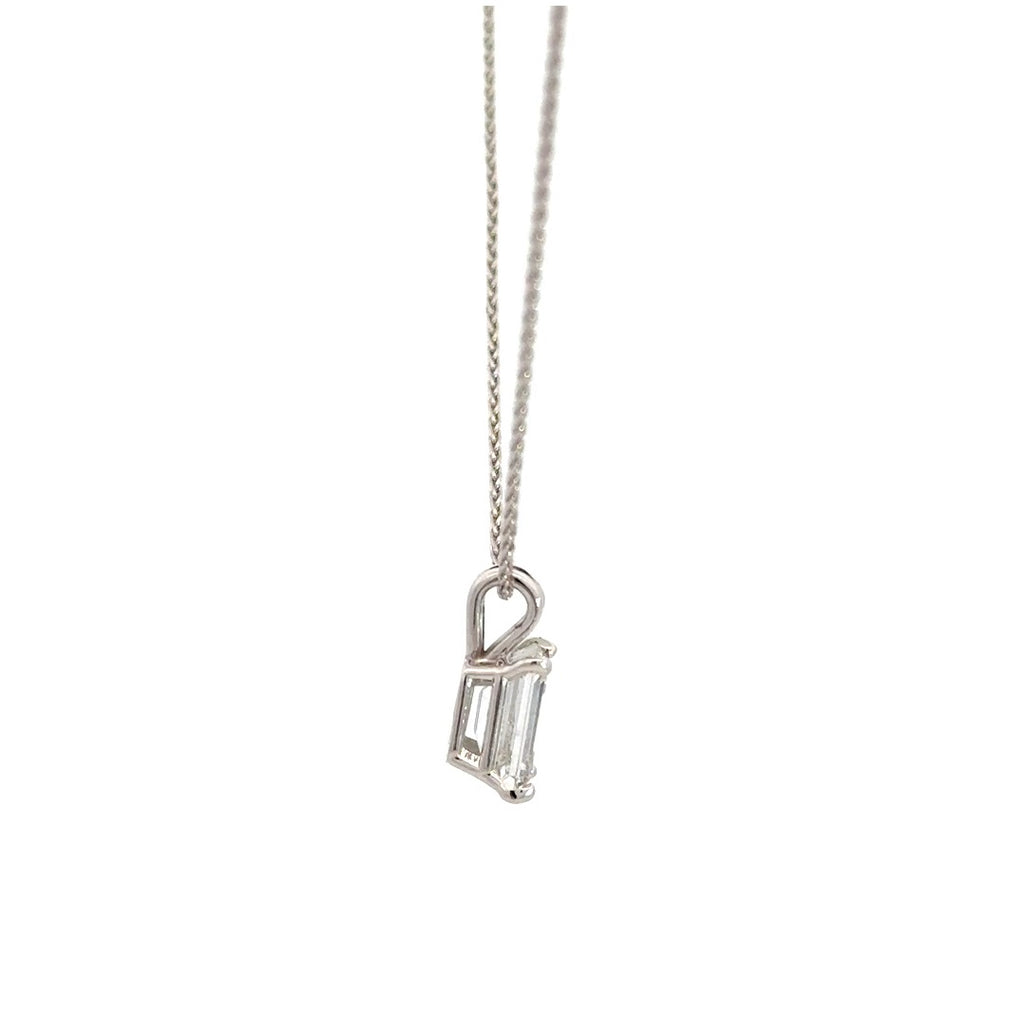 Side view of silver necklace with a emerald-cut diamond in a four-prong setting pendant on a white background.