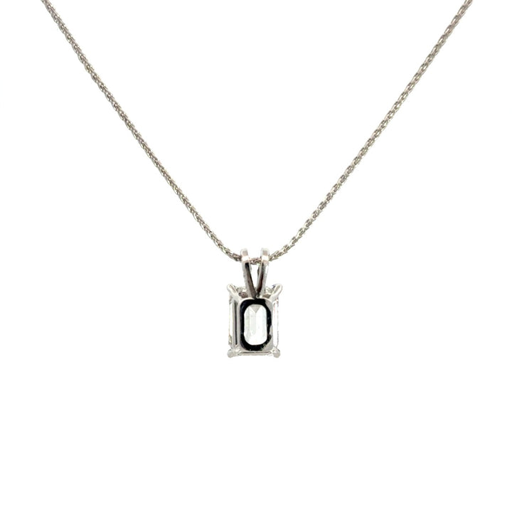 Back view of silver necklace with a emerald-cut diamond in a four-prong setting pendant on a white background.