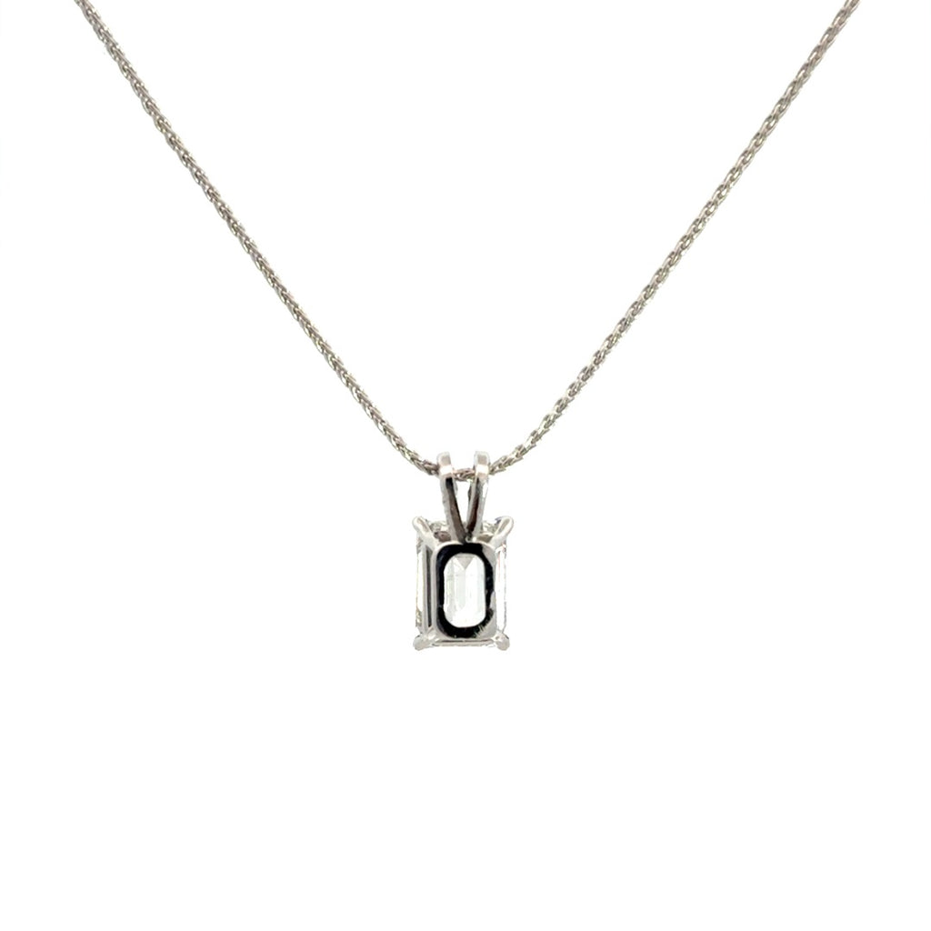 Back view of silver necklace with a emerald-cut diamond in a four-prong setting pendant on a white background.