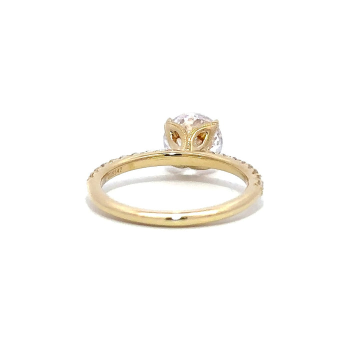 Back view of a gold engagement ring with a round-cut center diamond.