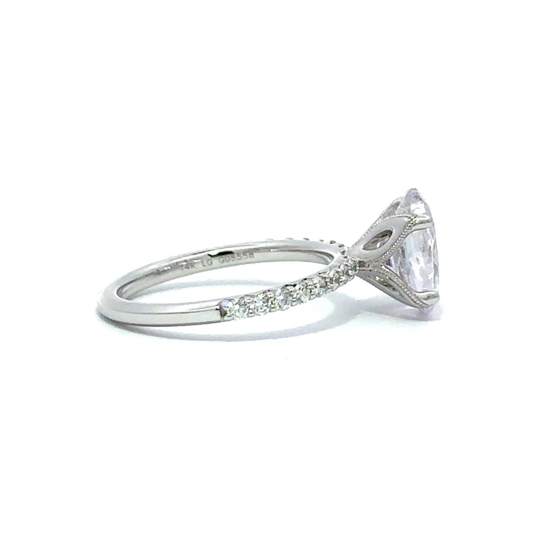 Side view of a silver engagement ring with a round-cut center diamond.