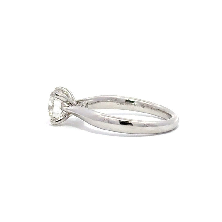 Side view of silver engagement ring with a round-cut center diamond.