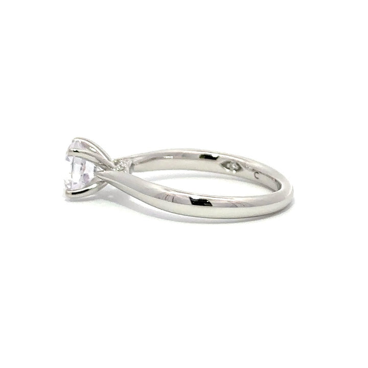 Side view of silver engagement ring with a round-cut center diamond.