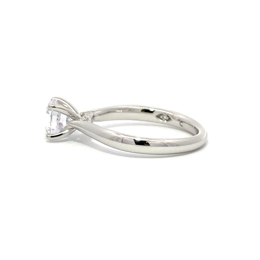 Side view of silver engagement ring with a round-cut center diamond.