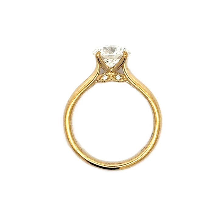 Gold engagement ring with a round-cut center diamond.