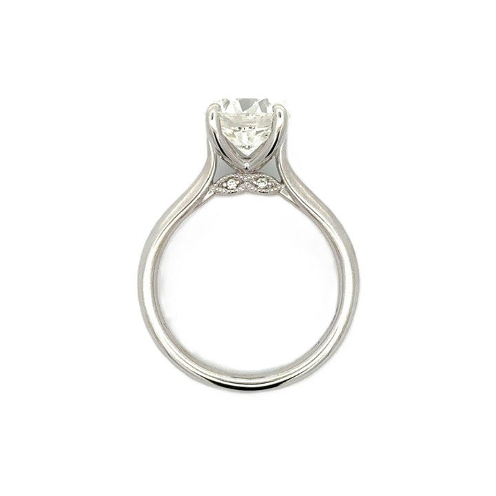 Silver engagement ring with a round-cut center diamond.