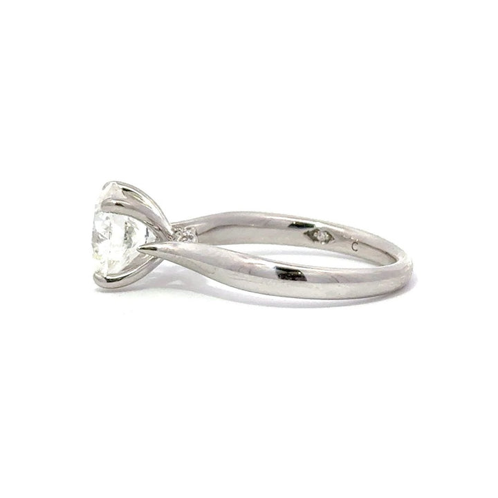 Side view of silver engagement ring with a round-cut center diamond.