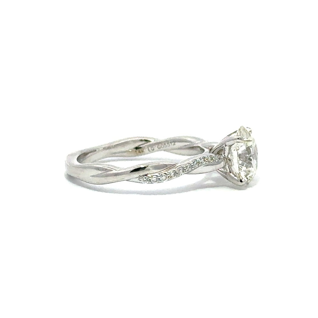 Side view of silver engagement ring with a round-cut center diamond.