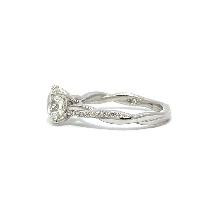 Side view of silver engagement ring with a round-cut center diamond.