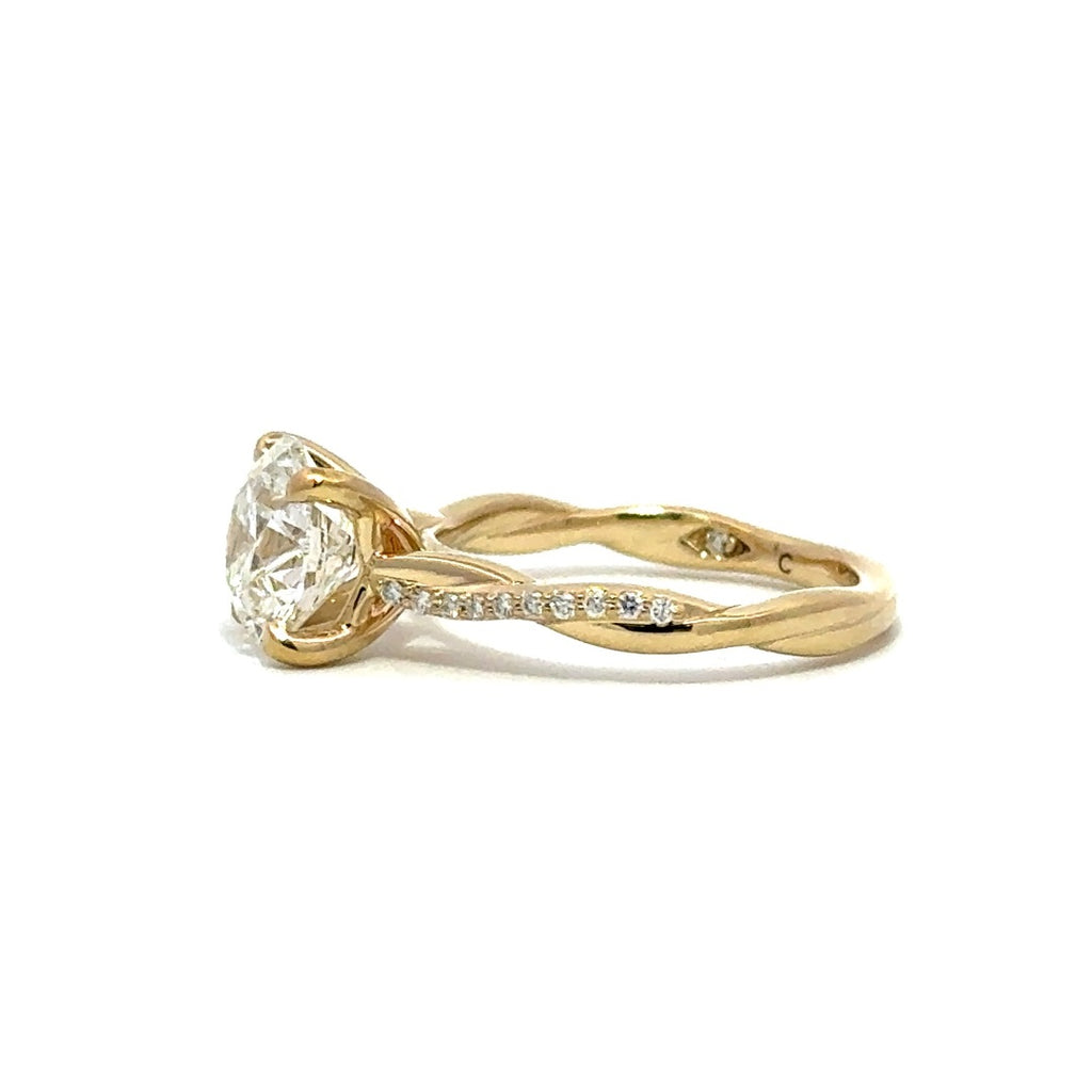 Side view of gold engagement ring with a round-cut center diamond.