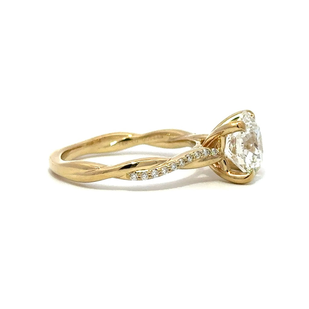 Side view of gold engagement ring with a round-cut center diamond.