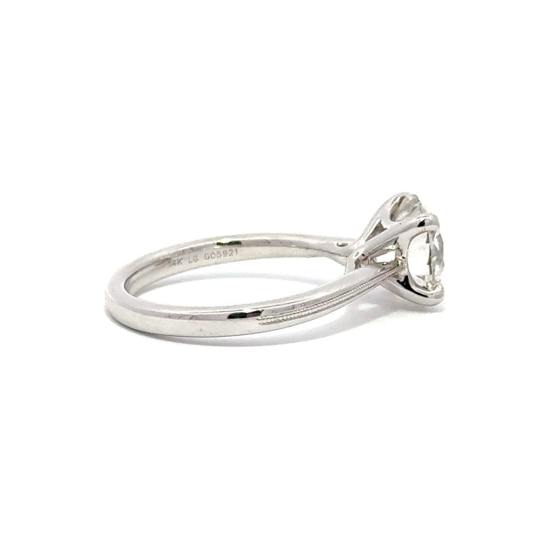 Side view of silver engagement ring with a round-cut center diamond.