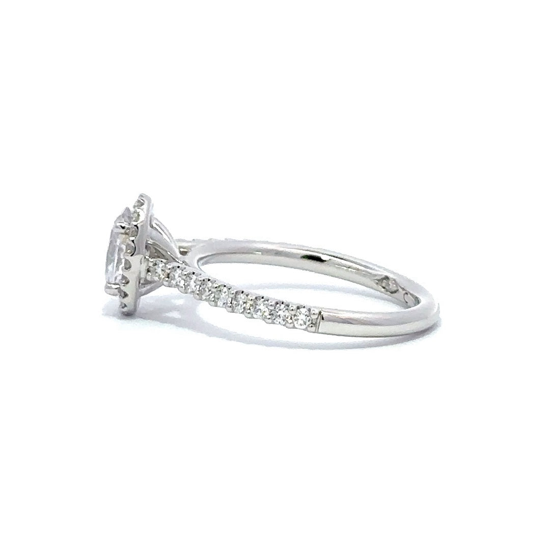 Side view of a silver engagement ring with a round-cut center diamond.