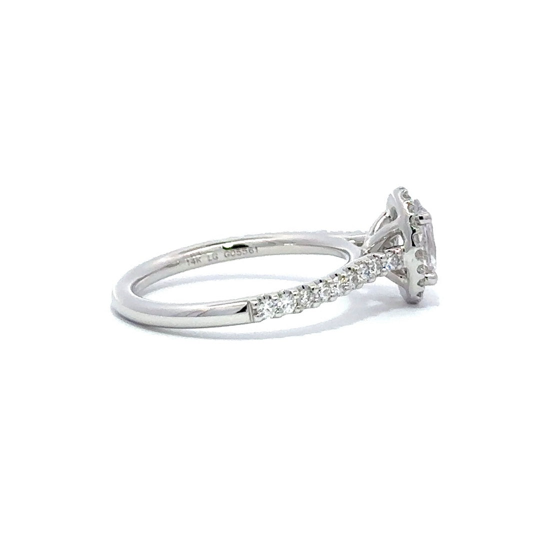 Side view of a silver engagement ring with a round-cut center diamond.