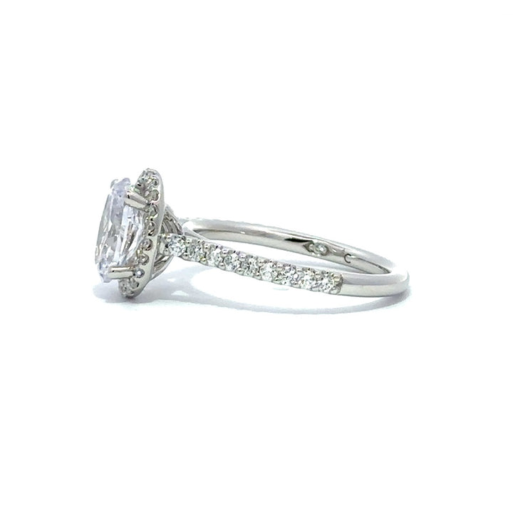 Side view of a silver engagement ring with a round-cut center diamond.