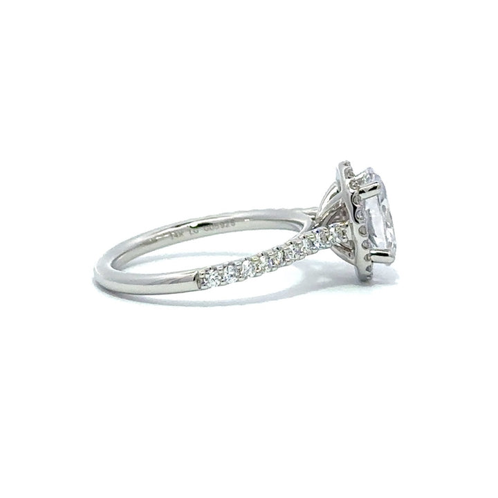 Side view of a silver engagement ring with a round-cut center diamond.