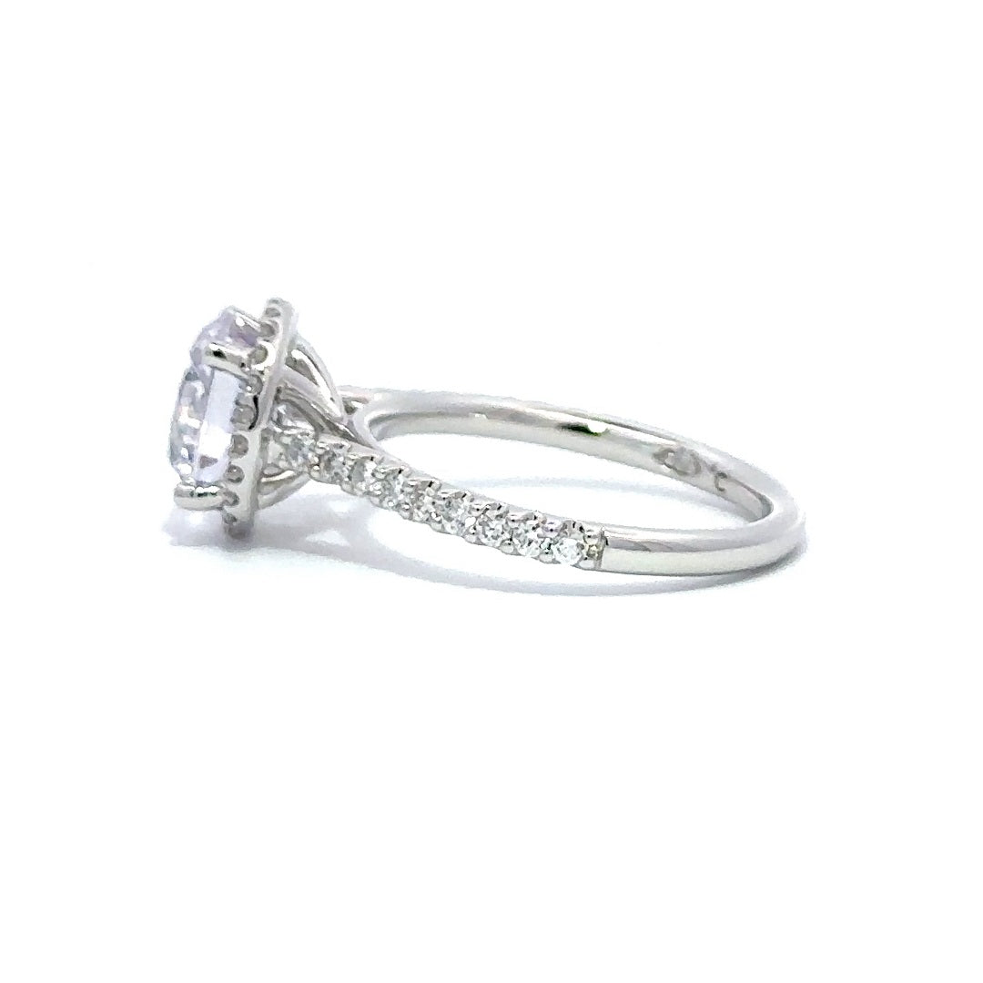 Side view of silver engagement ring with a round-cut center diamond.