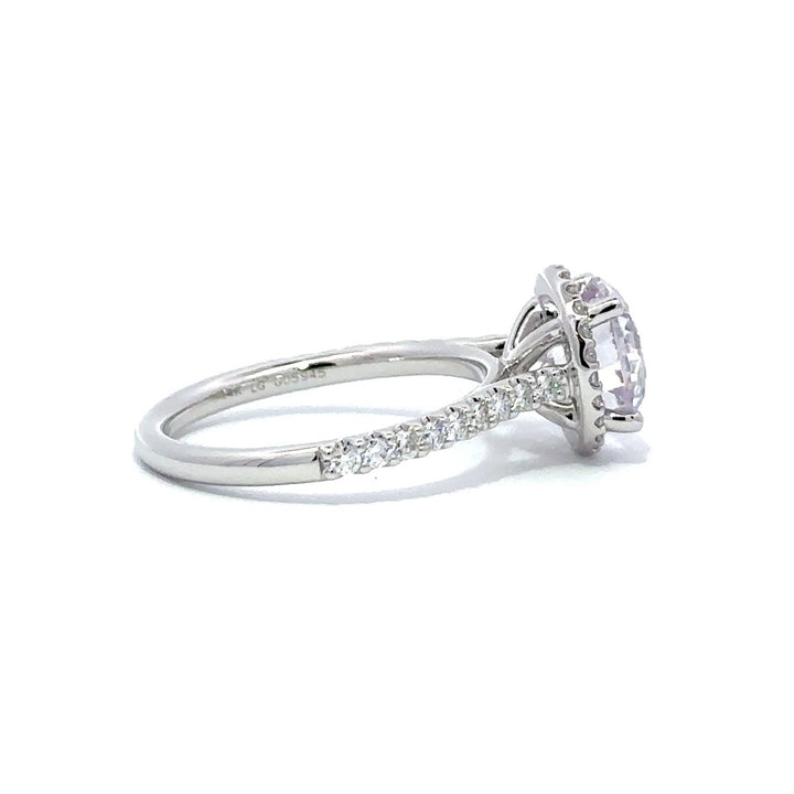 Side view of silver engagement ring with a round-cut center diamond.