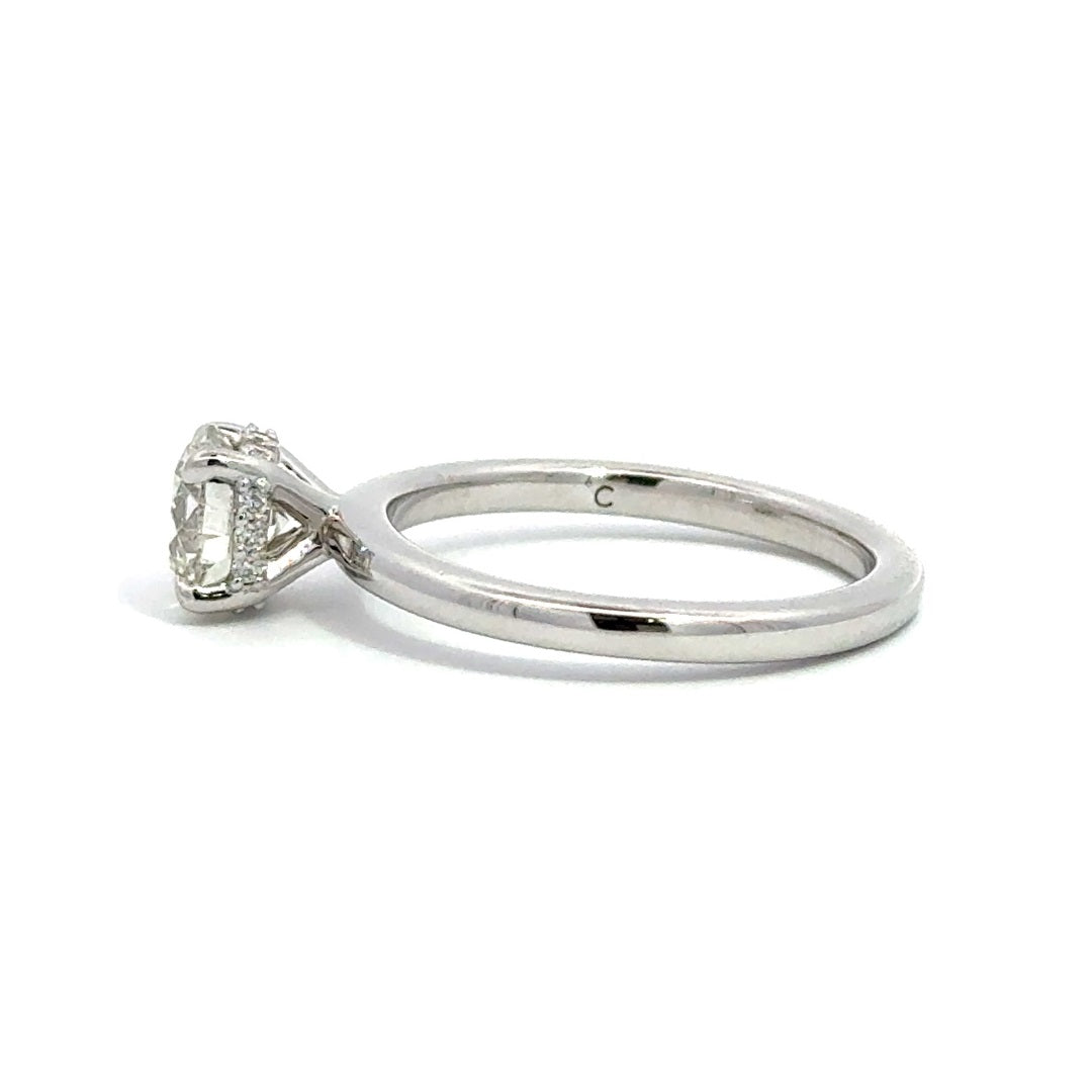 Side view of silver engagement ring with a round-cut center diamond.