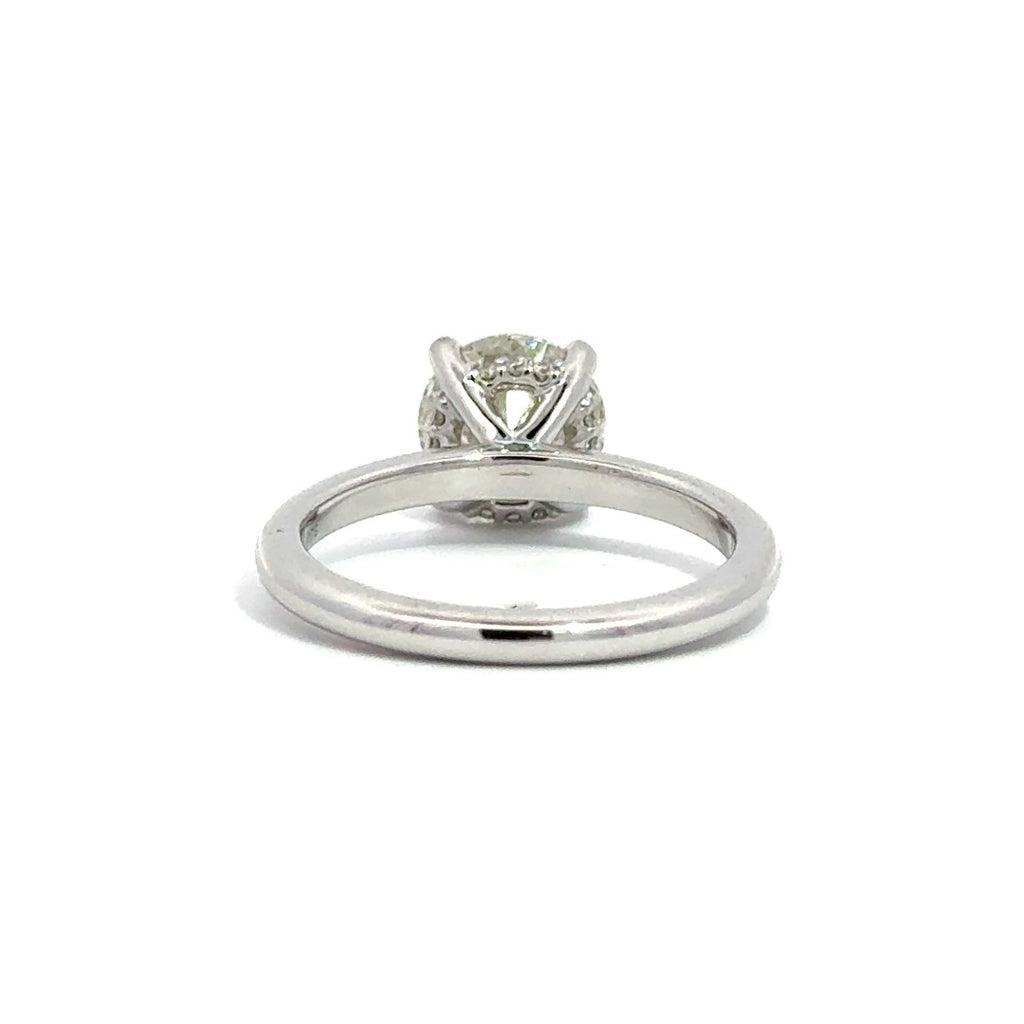 back view of silver diamond ring on a white table