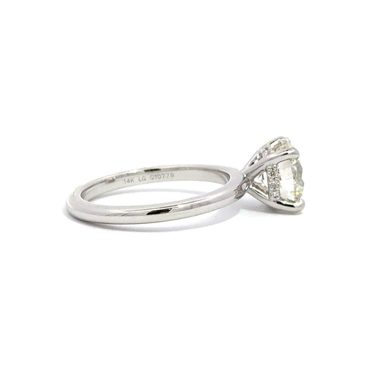 Side view of silver engagement ring with a oval-cut center diamond.