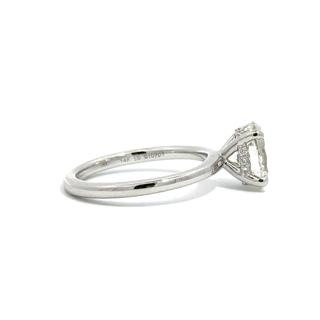 Side view of silver engagement ring with a oval-cut center diamond.