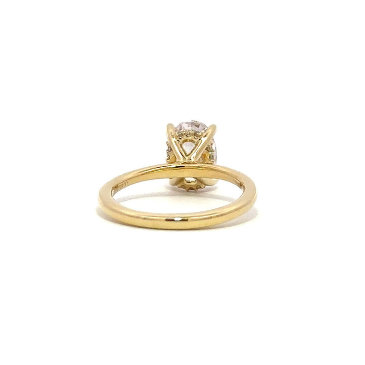 Back view of gold engagement ring with a oval-cut center diamond.