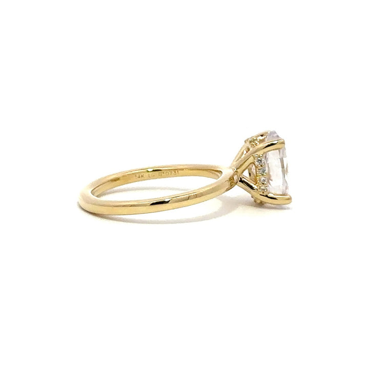 Side view of gold engagement ring with a oval-cut center diamond.