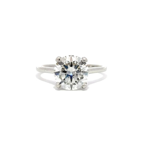 Silver solitaire engagement ring with a round-cut diamond center stone on a white background.