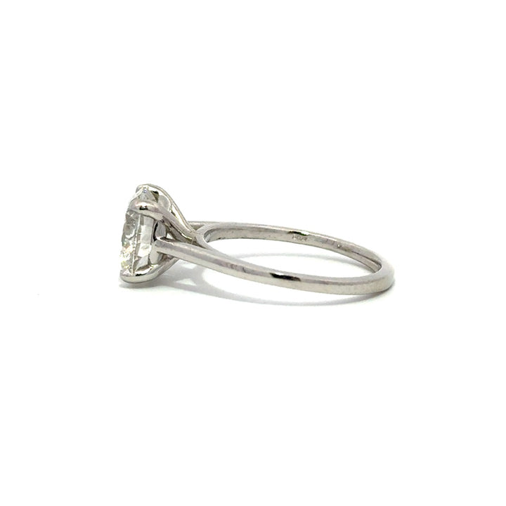 Silver solitaire engagement ring with a round-cut diamond center stone on a white background.