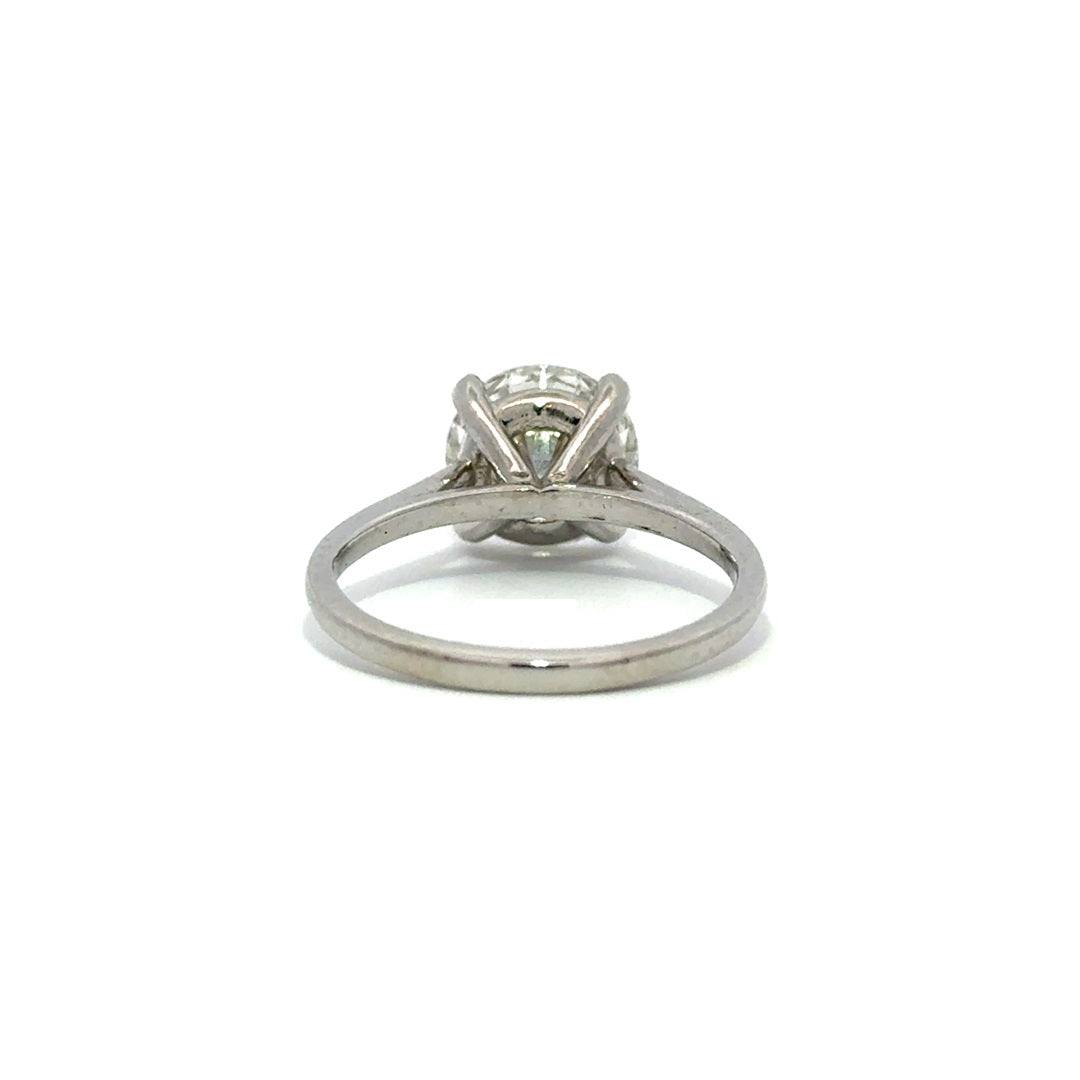 Silver solitaire engagement ring with a round-cut diamond center stone on a white background.