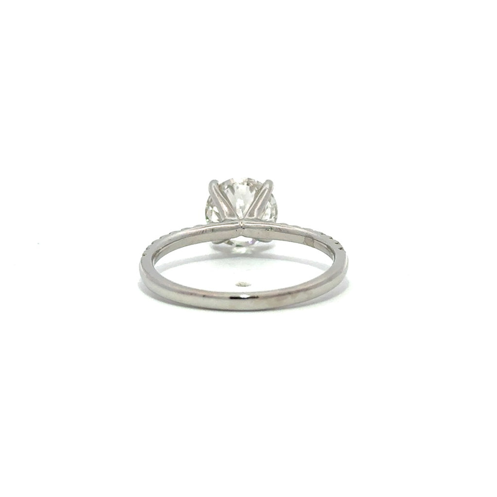 Silver gold solitaire engagement ring with a round cut diamond center stone on a white background.