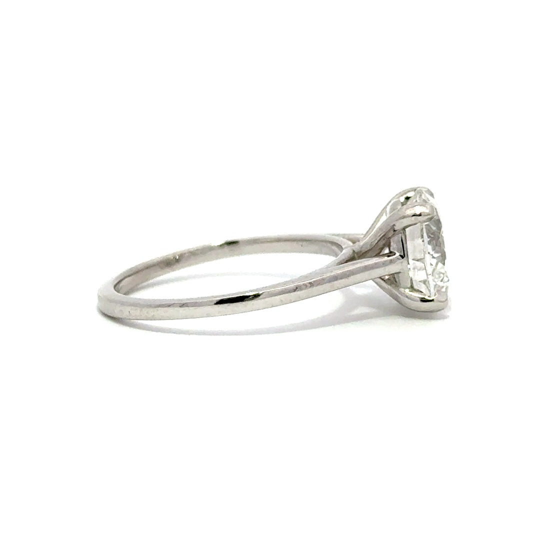 Silver solitaire engagement ring with a round-cut diamond center stone on a white background.