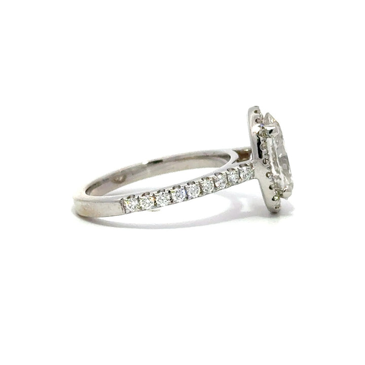 Silver ring with an oval-cut diamond center stone surrounded by a diamond halo and a diamond-studded band, on a white background.