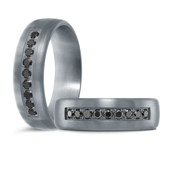 Titanium wedding band with a black carbon fiber inlay and black diamond accents on a white background.