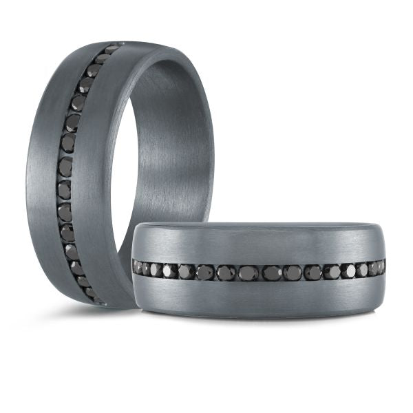 Titanium wedding band with a black carbon fiber inlay and black diamond accents on a white background.