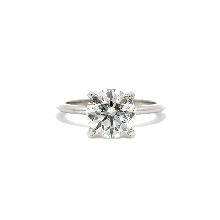 Silver solitaire engagement ring with a round-cut diamond center stone on a white background.