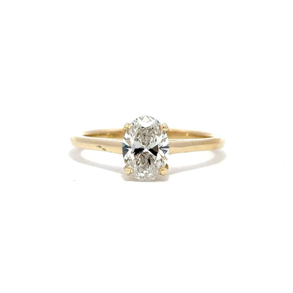 Yellow gold solitaire engagement ring with a oval cut diamond center stone on a white background.