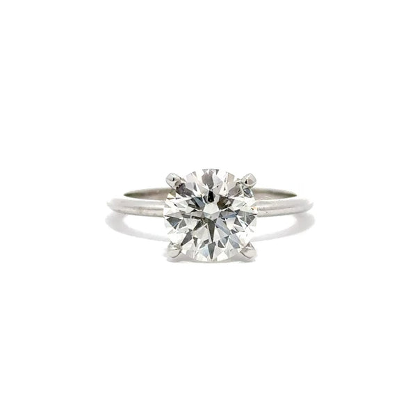 Silver solitaire engagement ring with a round-cut diamond center stone on a white background.