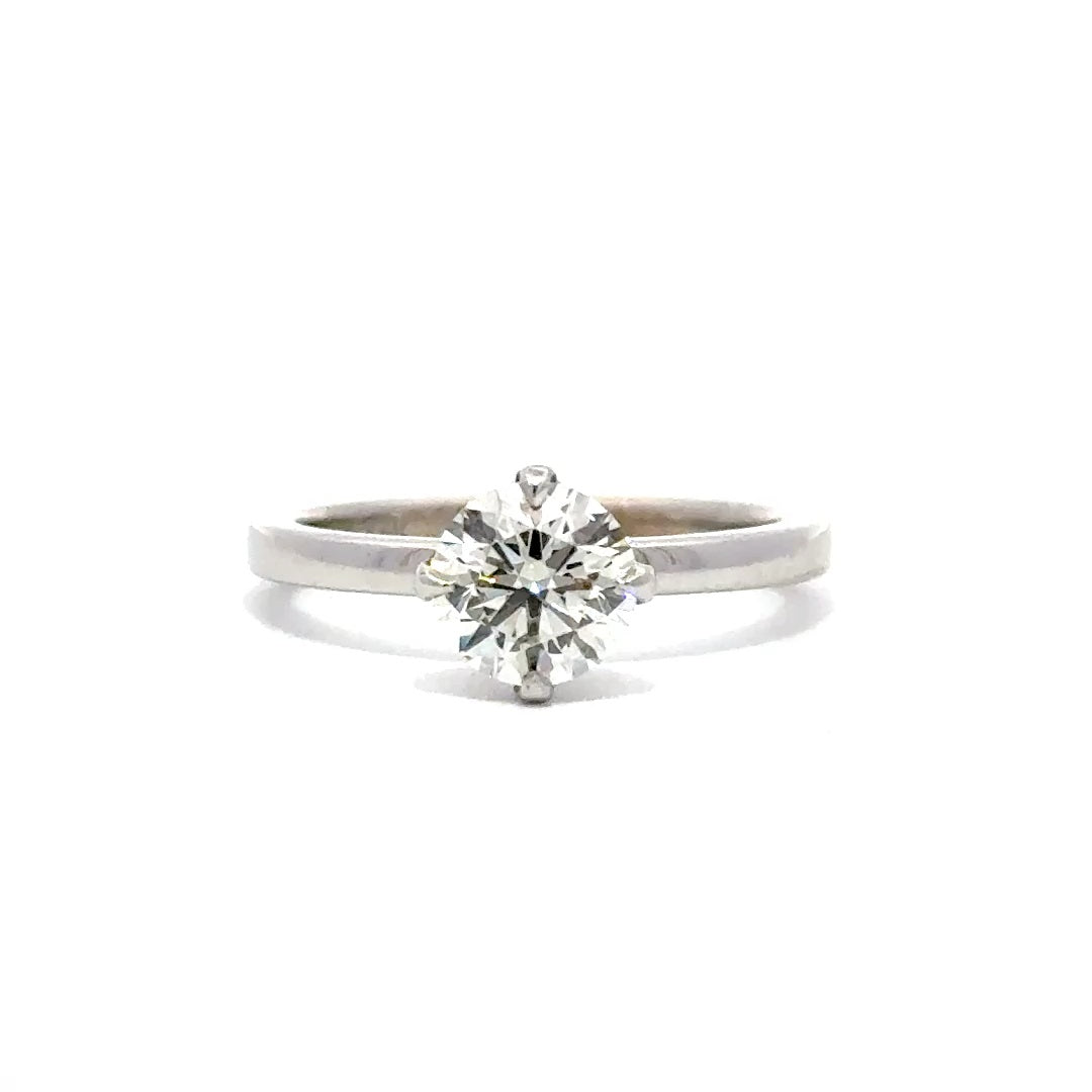 Silver gold solitaire engagement ring with a round cut diamond center stone on a white background.