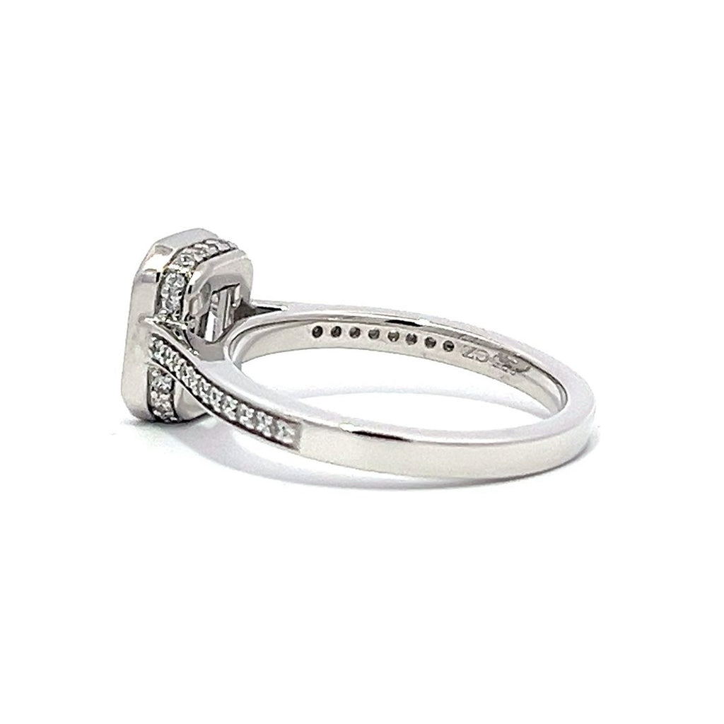 White gold emerald-cut diamond engagement ring with a diamond band on a white background.