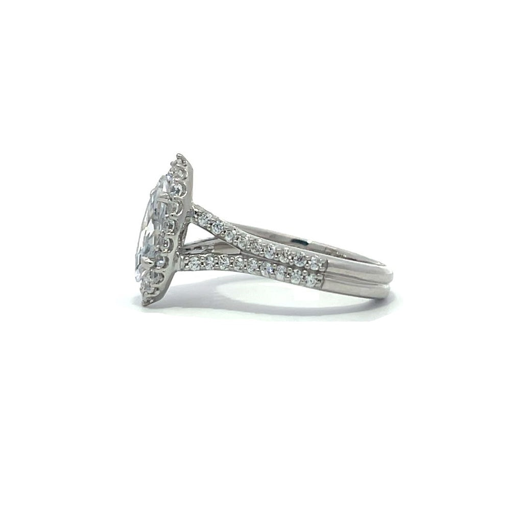 Silver pear-shaped diamond engagement ring with a halo setting and split shank on a white background.