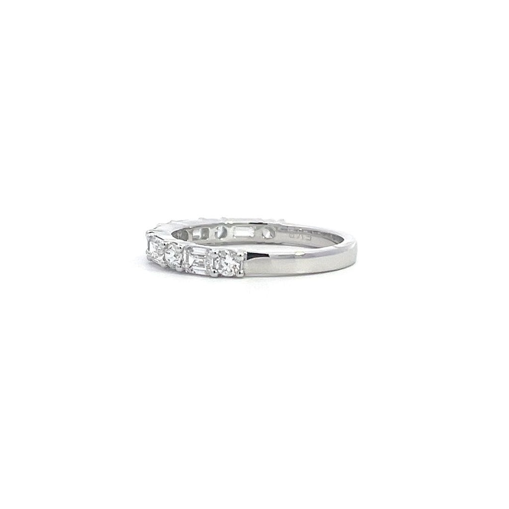 SIlver eternity band with alternating round and baguette-cut diamonds, on a white background.