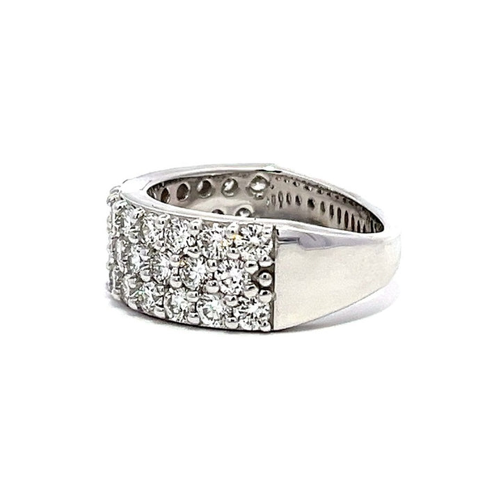 White gold eternity band with three rows of pave-set diamonds on a white background.