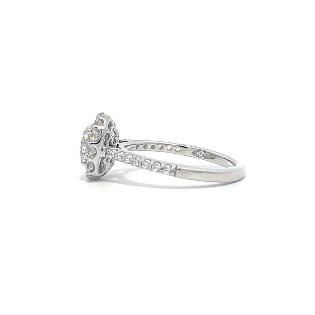 Silver engagement ring with a diamond halo setting and a diamond band on a white background