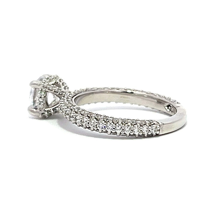 White gold round-shaped diamond engagement ring with a diamond band on a white background.