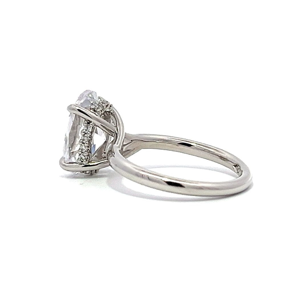 White gold oval diamond solitaire engagement ring on a white background