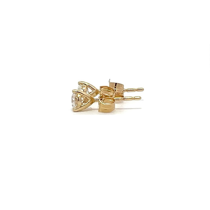 Pair of yellow gold stud earrings with round diamonds on a white background.