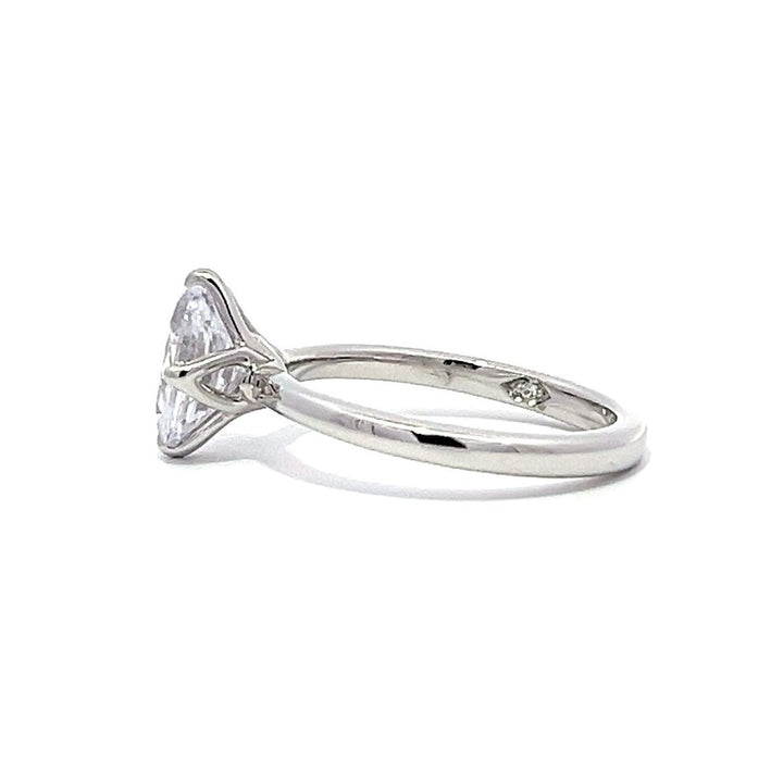 White gold oval diamond solitaire engagement ring on a white background.