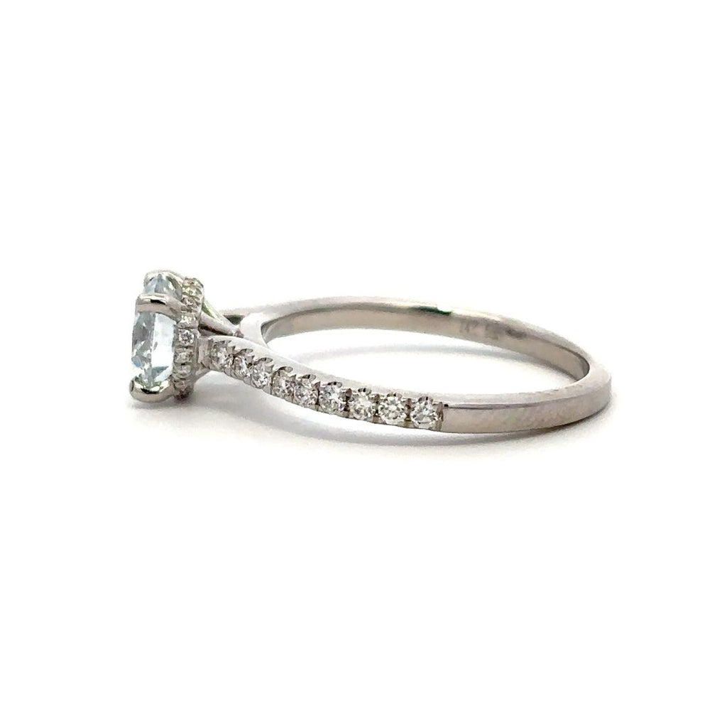 White gold diamond engagement ring with a halo setting and a diamond band on a white background.